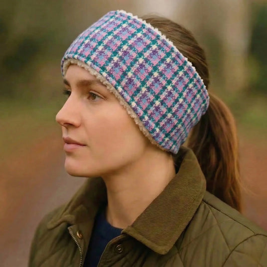 Person wearing a plaid headband and green jacket outdoors