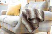 collared Creatures Luxury Dog Blanket -Sofa Throw In Brown Faux Fur displayed on a modern grey check sofa