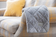 collared Creatures Luxury quilted Dog Blanket -Sofa Throw In Grey Faux Fur displayed on a modern grey check sofa