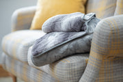 Collared Creatures Luxury Dog Blanket -Sofa Throw In Grey Faux Fur displayed on a modern grey check sofa