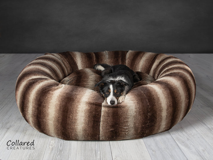 Tess who is a Collie looking warm and cosy in Collared Creatures gorgeous, luxury  brown deluxe donut dog bed