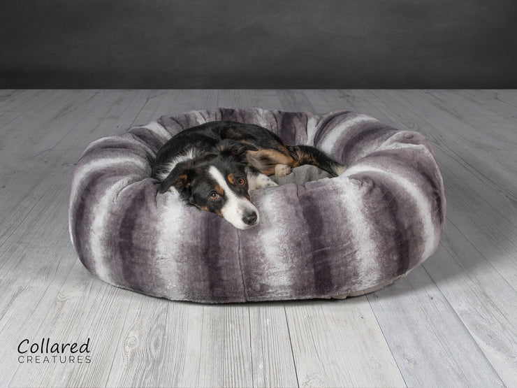 Tess who is a Collie looking warm and cosy in Collared Creatures gorgeous, luxury grey deluxe donut dog bed