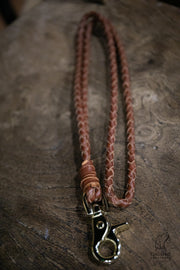 rich tan braided leather lanyard by Collared Creatures sat on a dark wooded block