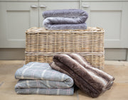 Collection of Collared Creatures Luxury dog blanket - sofa throw displayed on a wicker basket